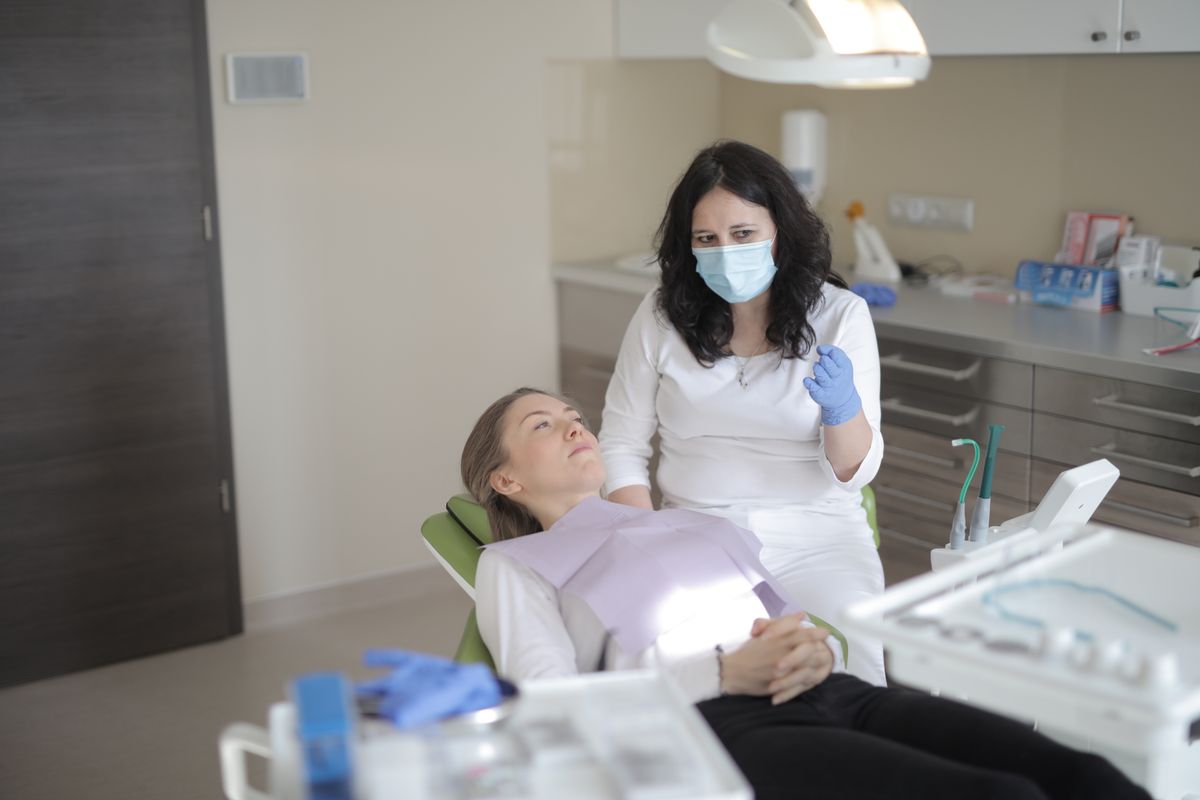 Dentista e paziente durante un trattamento odontoiatrico da verificare se finanziato e non completato