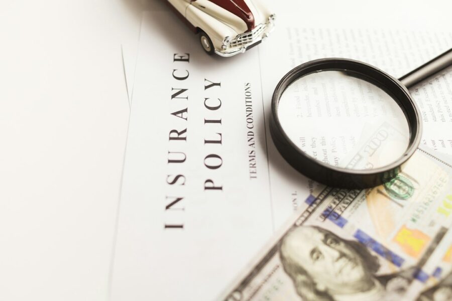 Documenti e lente d'ingrandimento per la valutazione di una pratica assicurativa