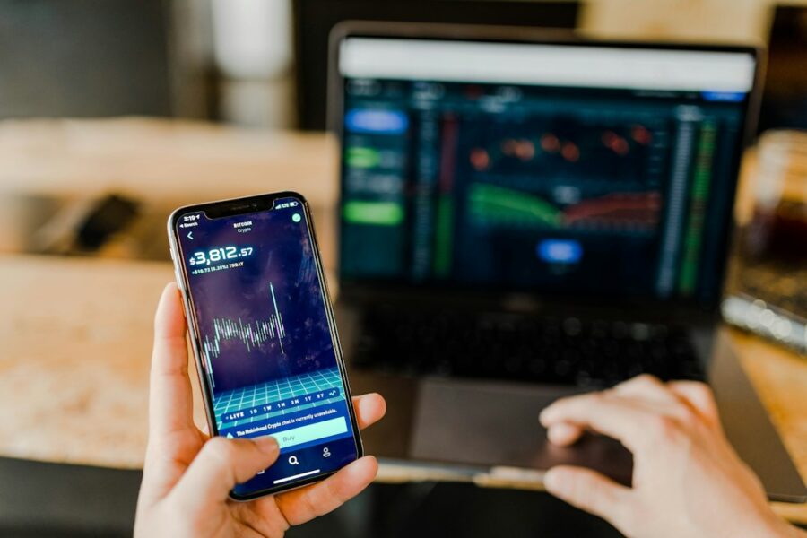 Investitore consulta dati finanziari su smartphone e computer