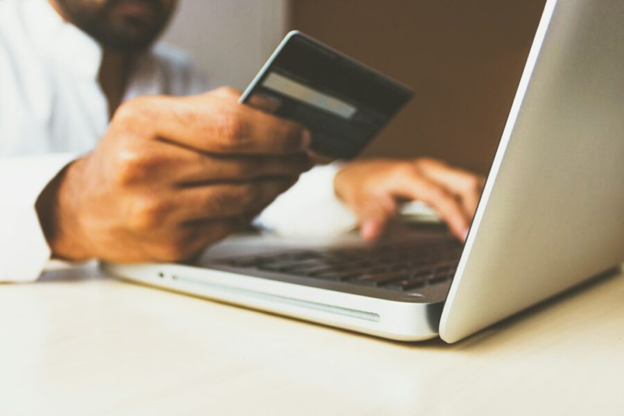 Pagamento online con computer e carta, immagine illustrativa per trading e servizi finanziari