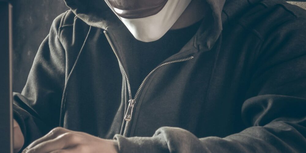 Persona anonima al computer, immagine relativa a un profilo falso online